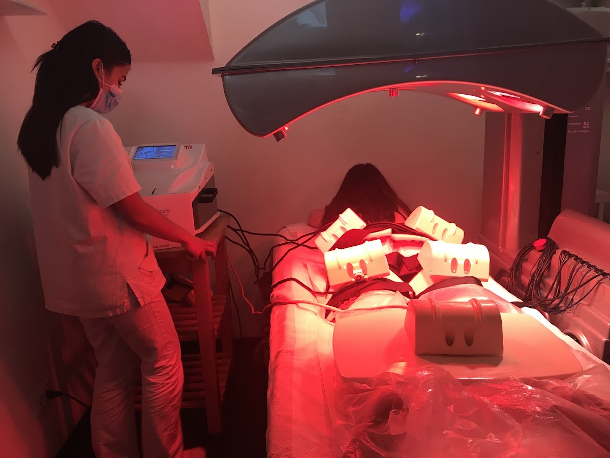 Estetista durante un trattamento corpo con tecnologia a luce