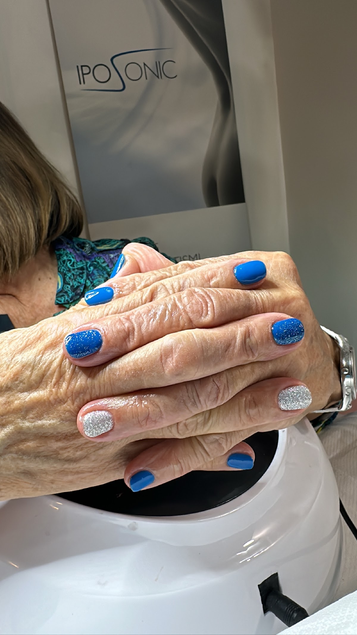 Manicure con smalto semipermanente blu e finitura glitter